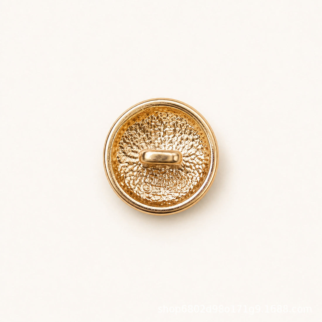 Round metal shank button with white embossed face and gold double-ring stripe