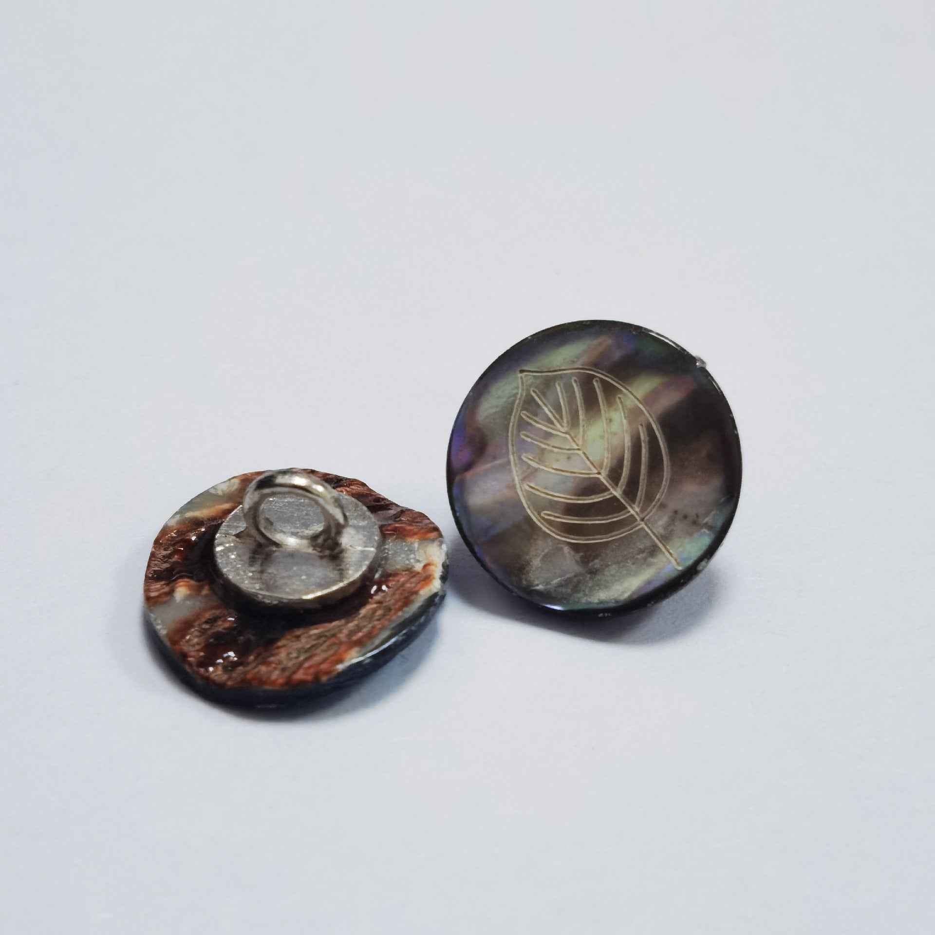 Abalone-Knöpfe mit Blattmuster, dunkle irisierende Oberfläche, Metallsteg sichtbar