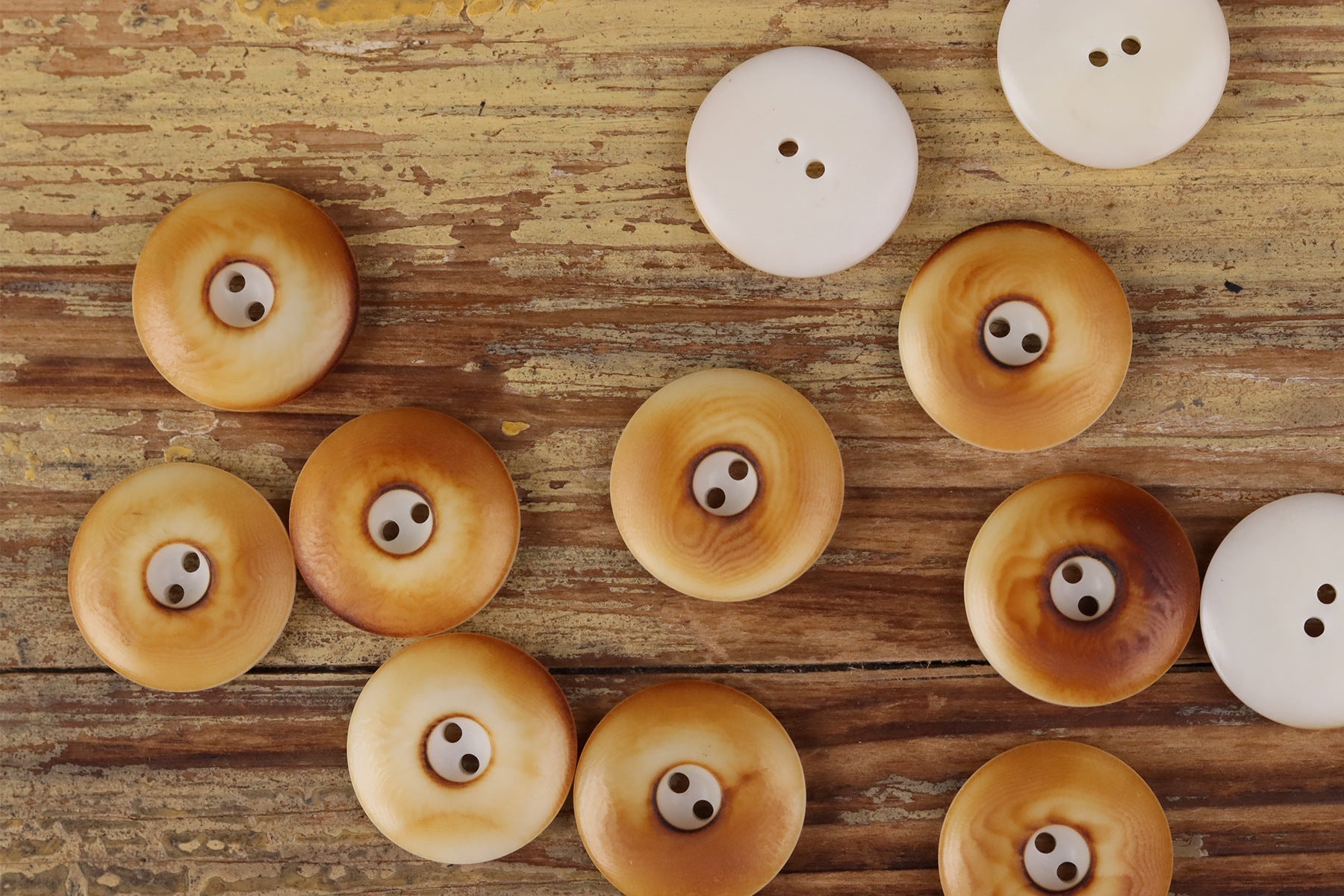 Assorted round two-hole seed buttons in white and golden tan tones
