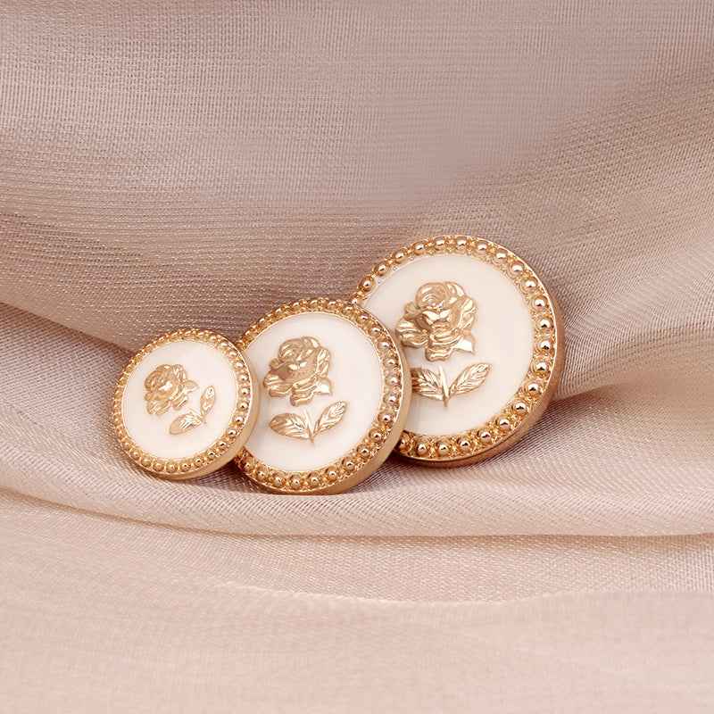 Round metal rose shank buttons with gold rims and white faces, embossed roses