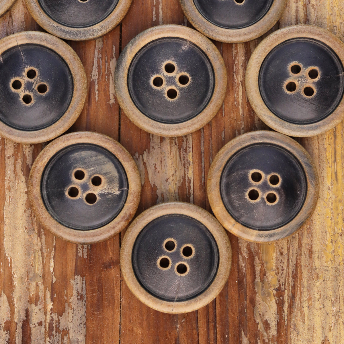 Pack of round 4-hole coat buttons with burnished tan outer rims