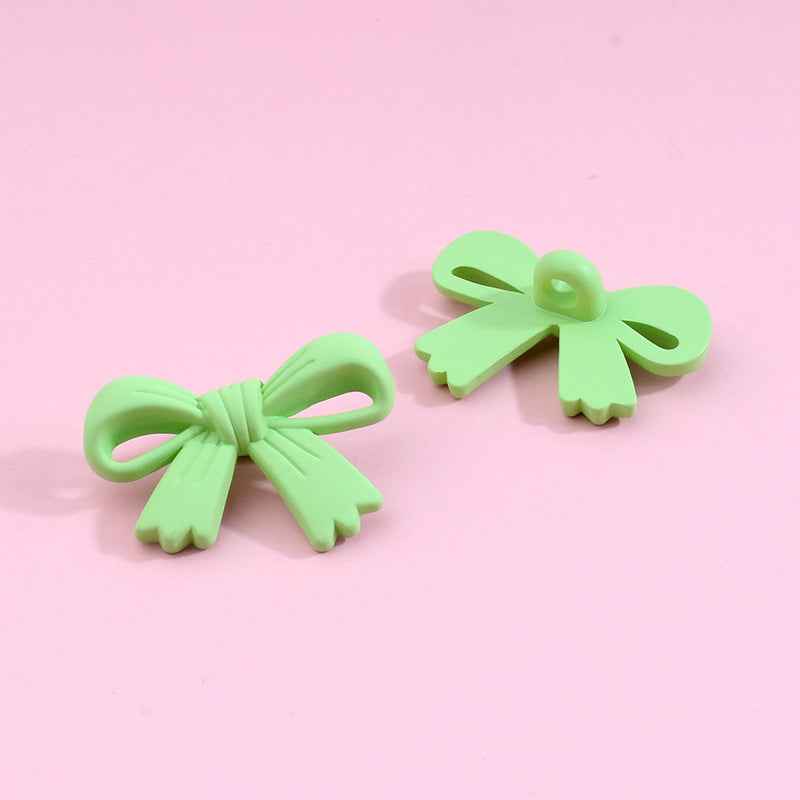 Light green bow-shaped plastic shank buttons with loop shanks, 2-piece view