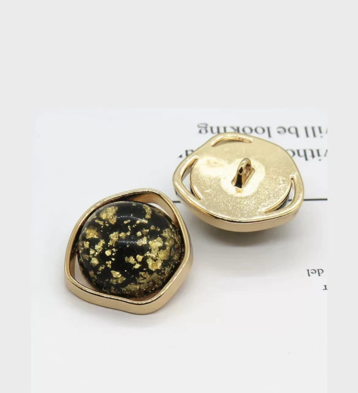 Schwarze Naturmuschel-Knöpfe mit goldfarbenem Metallrand und Schaft, unregelmäßig