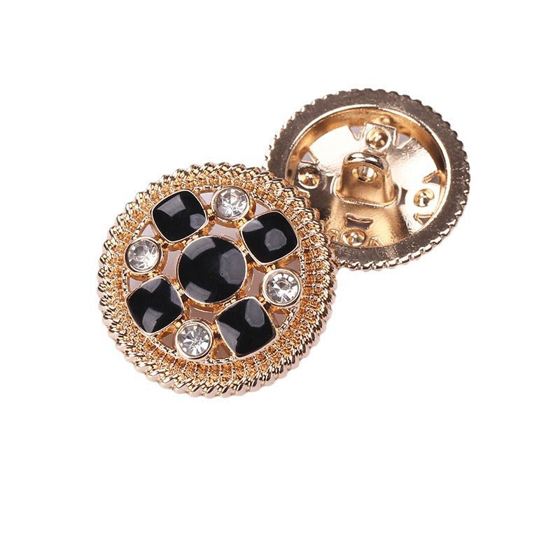 Round crystal shank button: black enamel discs, gold-tone bezel, rhinestone accents