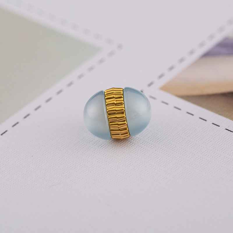 Nahaufnahme Resin-Knopf, hellblau mit goldfarbenem geripptem Metallsteg