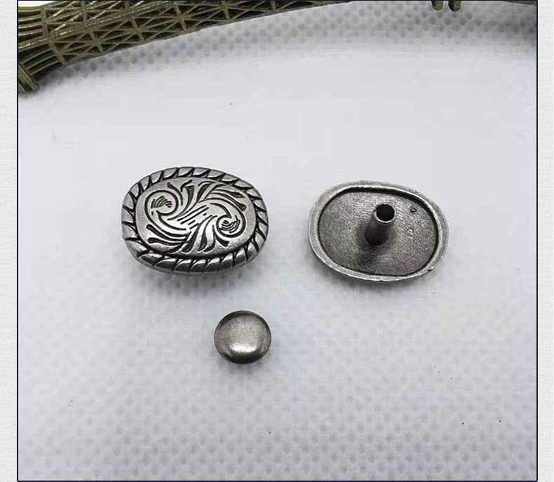 Ornate metal rivet studs: oval floral scroll, bow front, and round scroll caps.