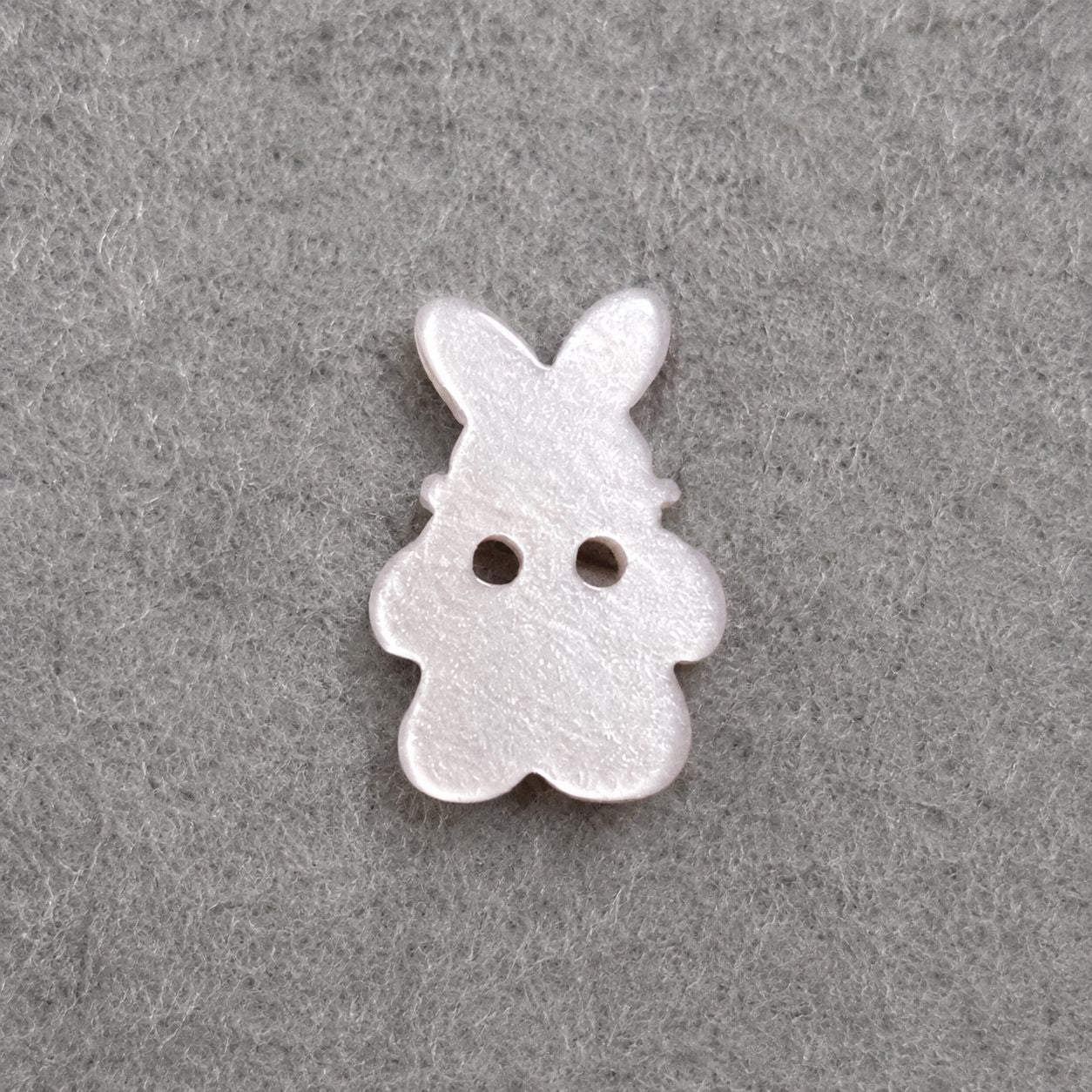 White bunny resin sew-on button with two holes, stitched-look edges