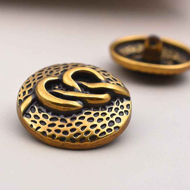 Round antique metal coat buttons with decorative swirl pattern and shank, light gold