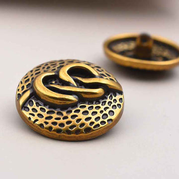 Round antique metal coat buttons with decorative swirl pattern and shank, light gold