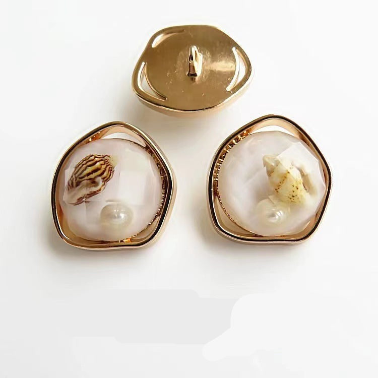 Beige/weiße Naturmuschel-Knöpfe mit goldfarbenem Metallrand und Schaft, unregelmäßig