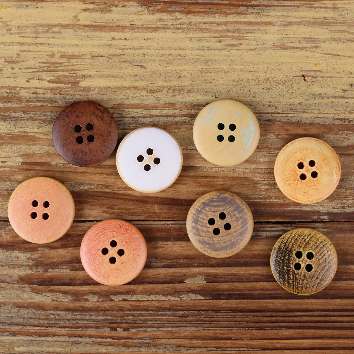 Set of round 4-hole wood buttons in dark, peach, white, and gray tones
