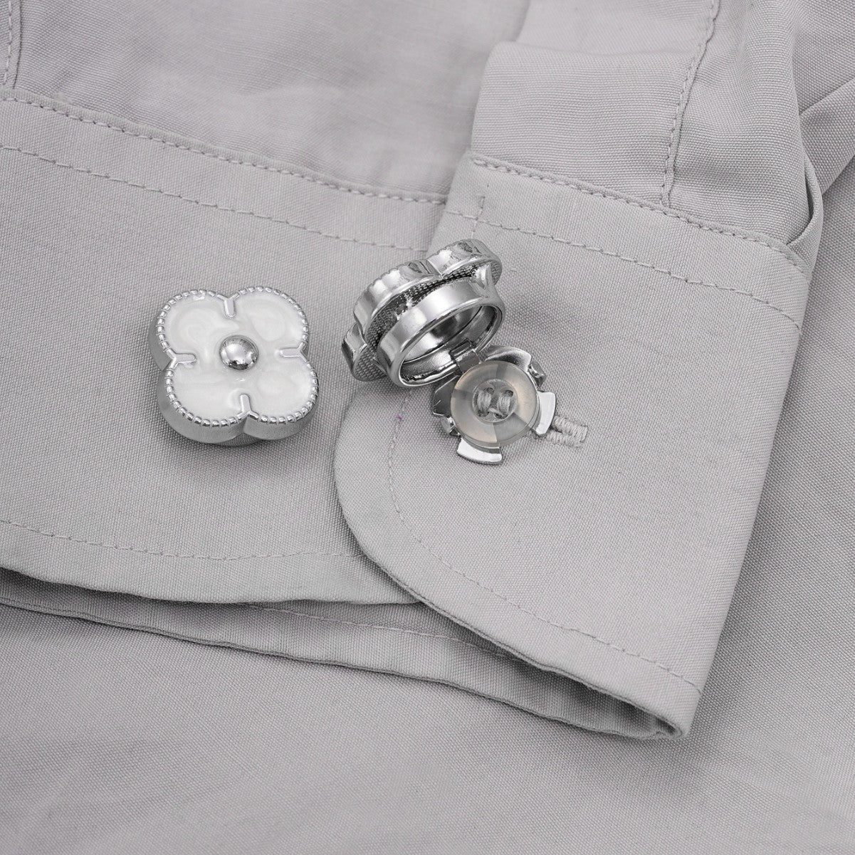 Silberfarbener Clip-Knopf mit vierblättrigem Kleeblatt am Kleidungsrand