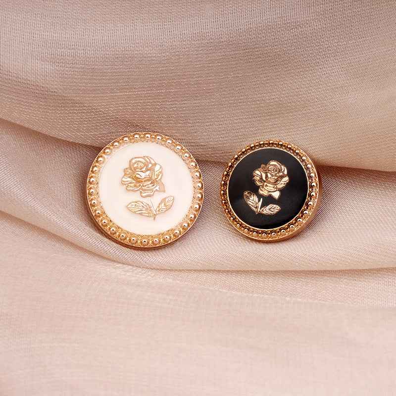 Set of round rose shank buttons: one white and one black, gold rims and embossed roses