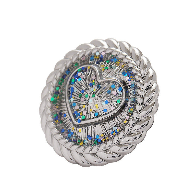 Gold heart-shaped metal shank button with braided rim and glitter mosaic center
