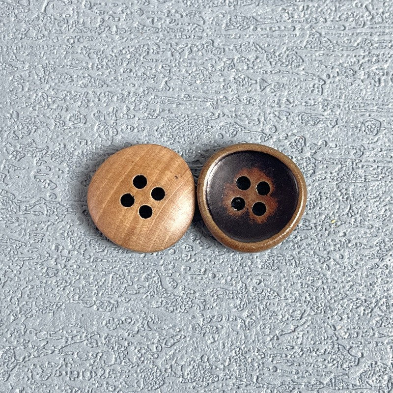 Four-hole wood buttons, brown face with dark inset and bronze rim, paired.