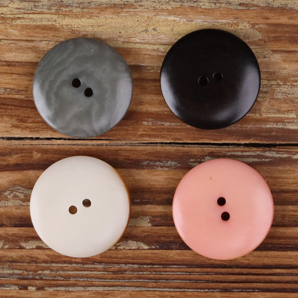 Round two-hole seed buttons in grey, black, white, and pink, assorted