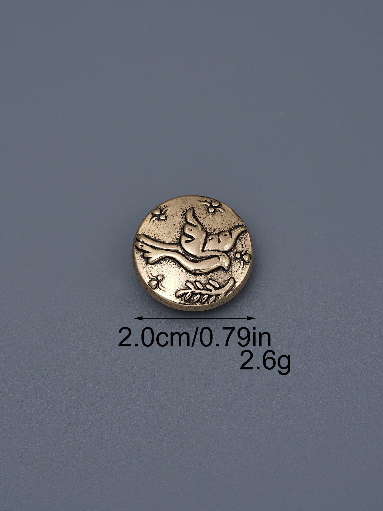Gold-toned embossed metal shank button with flying bird design, ~2.0cm
