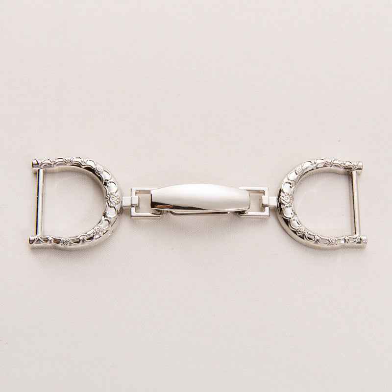 Oversized belt buckle clasp, silver-tone finish with textured oval edges and central latch bar