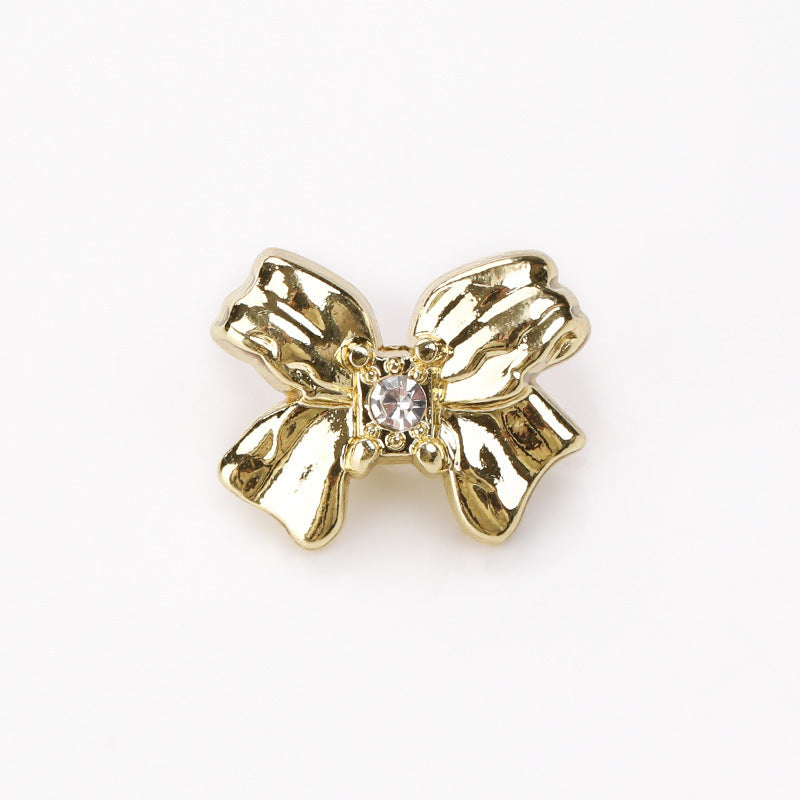 Light gold-toned crystal bow button with raised metal butterfly design