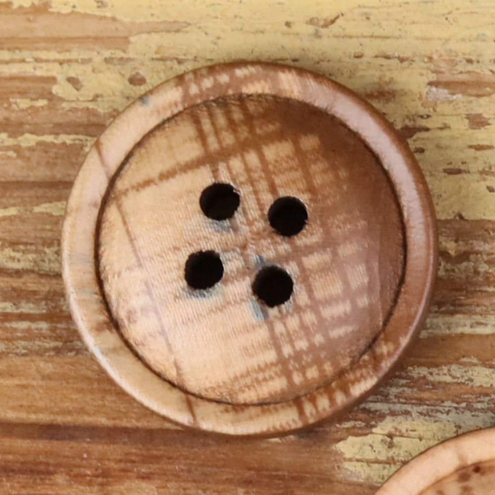 4-hole round button close-up, light tan plaid fabric with four black holes
