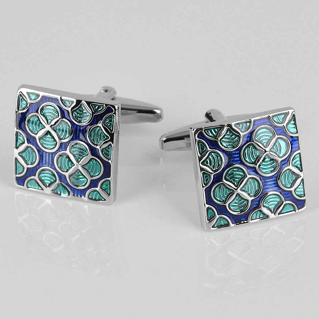 Pair of square enamel cufflinks with silver backs and blue-green floral design.