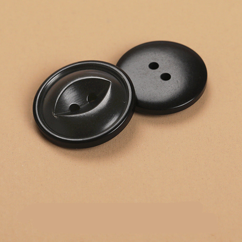 Black round 2-hole buttons, two-piece close-up with holes