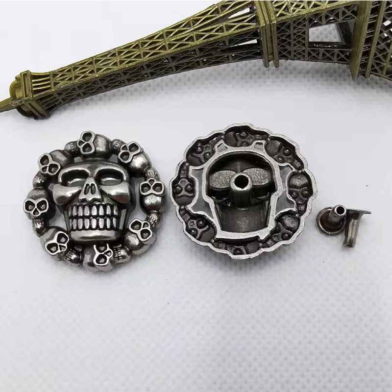 Skull rivet studs, silver-tone with skull faces and spikes; size 28–29 mm