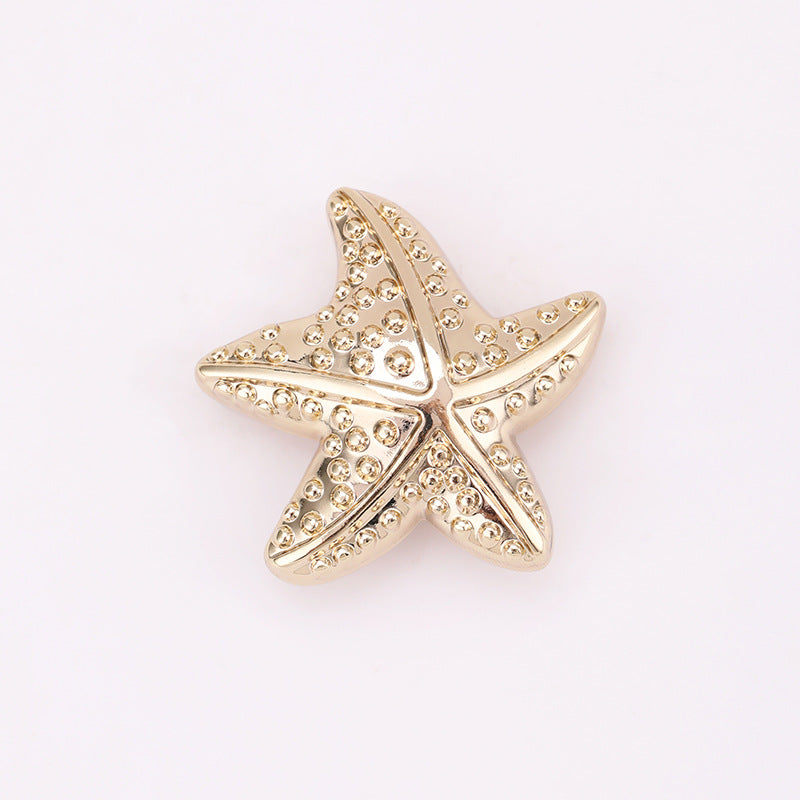 Light gold puffy starfish metal shank button with rhinestone-like detail