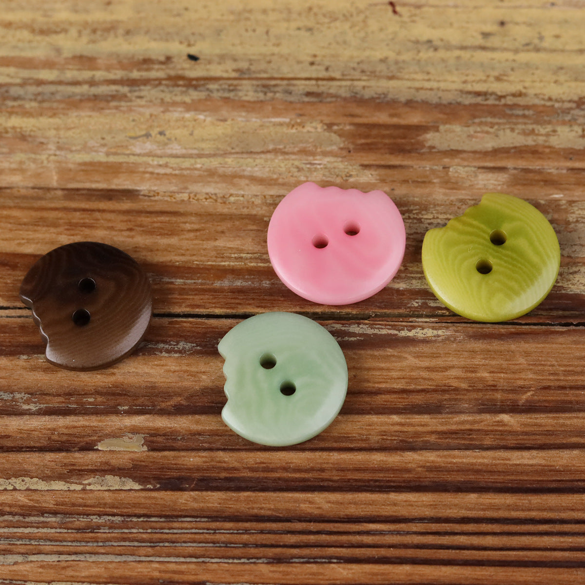 Set of irregular seed buttons: brown, pink, light green, each with two holes.