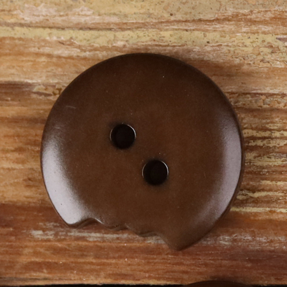Brown irregular seed button with two holes, natural two-piece edge detail.