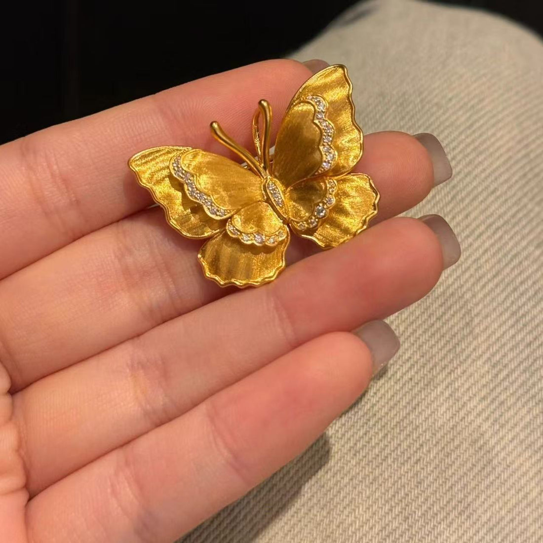 Gold brushed butterfly brooch pin with matte vintage finish and rhinestone detail