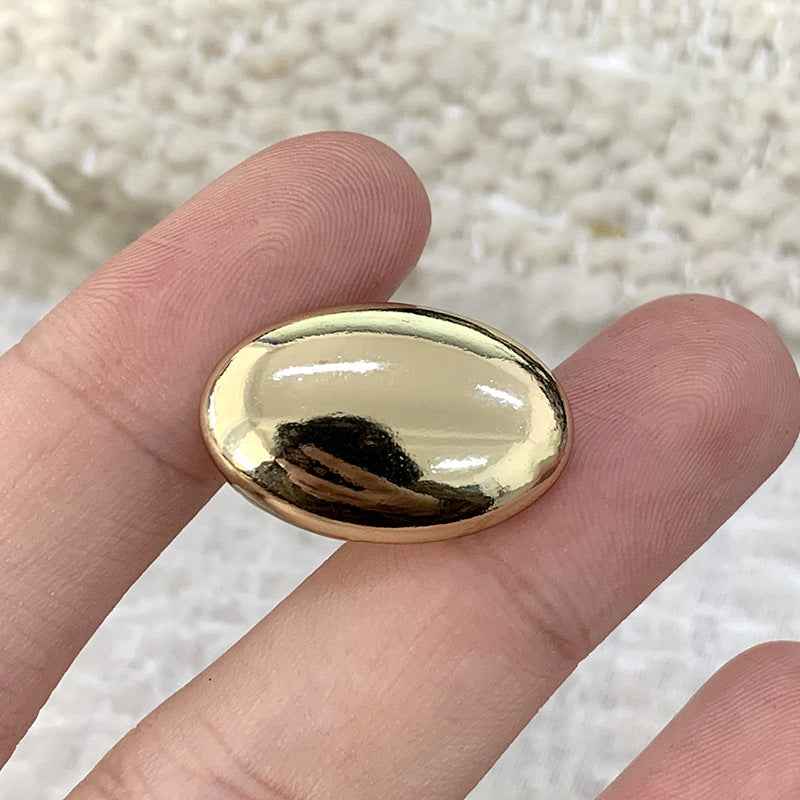Oval smooth gold alloy shank button, shiny domed front for sweaters