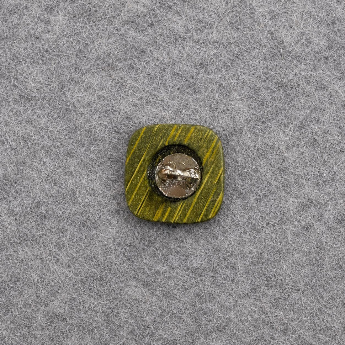 Green square shank button with stitched cross pattern, glossy woodgrain