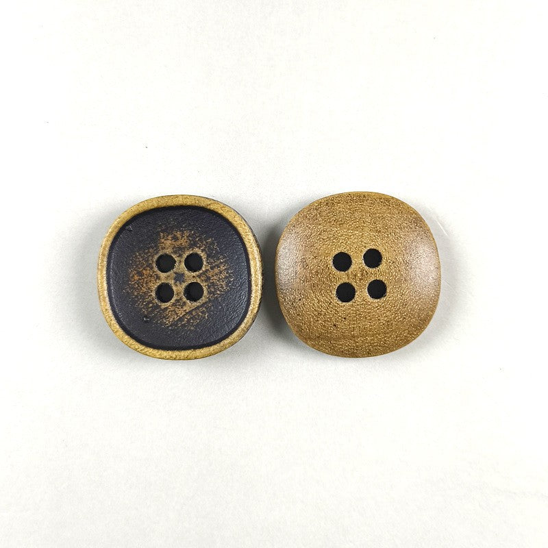 Two round four-hole wood buttons in dark blue-gray and tan tones