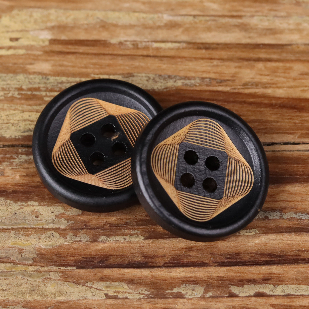 Pair of round 4-hole buttons with striped wood faces and black centers on black rims