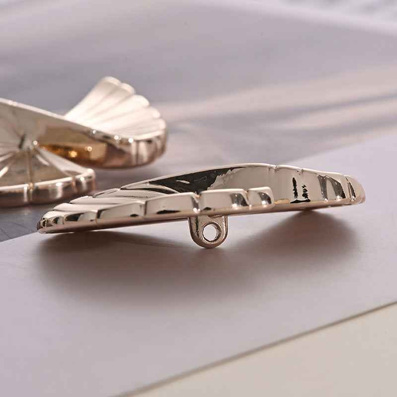 Fan-shaped metal button underside with shank and ridged folded details