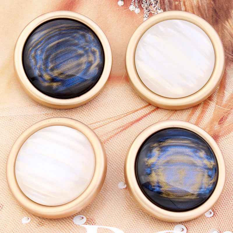 Round cat’s eye shank buttons in white and blue-black with gold rims