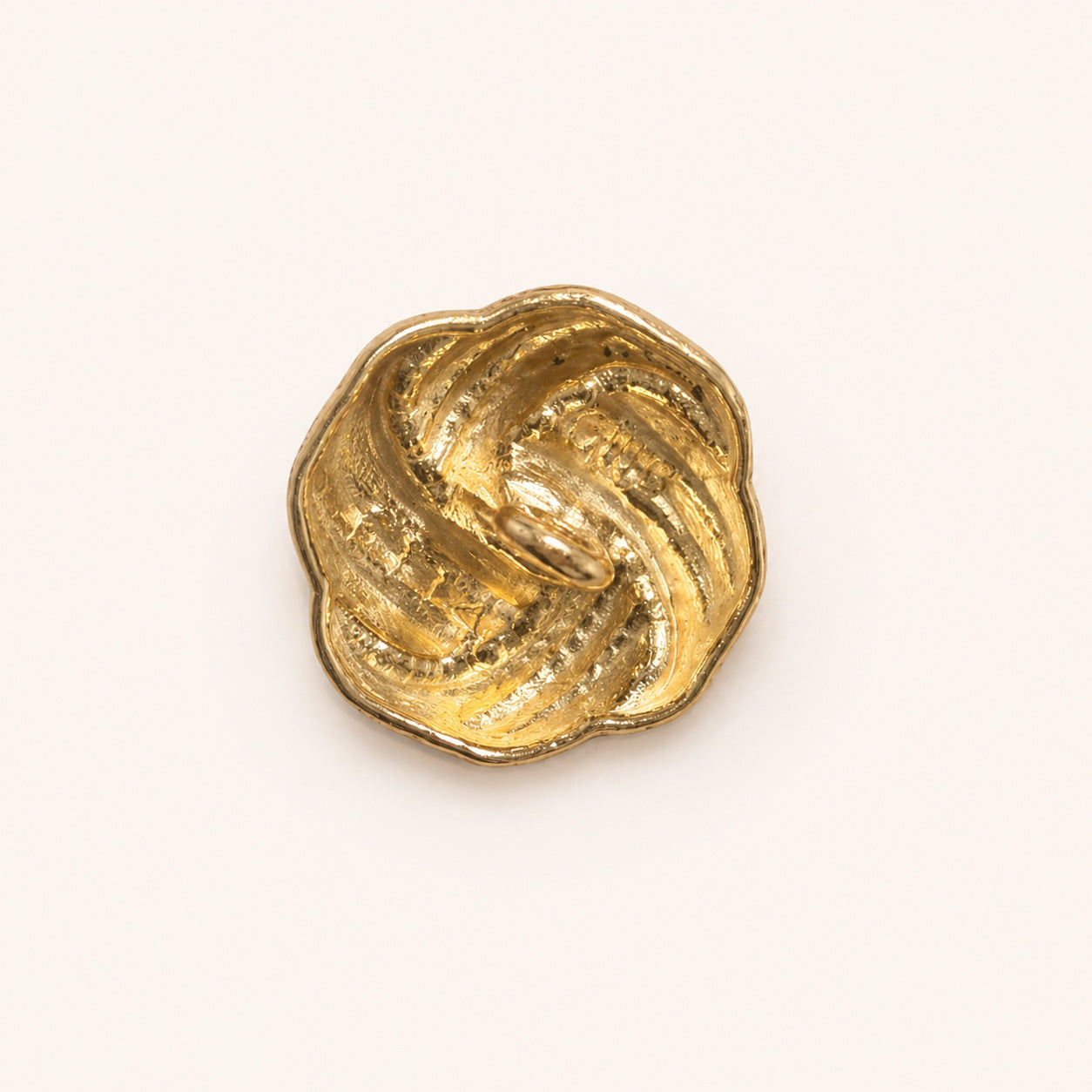 Gold metal Chinese knot shank button, flat back with central loop and textured ridges