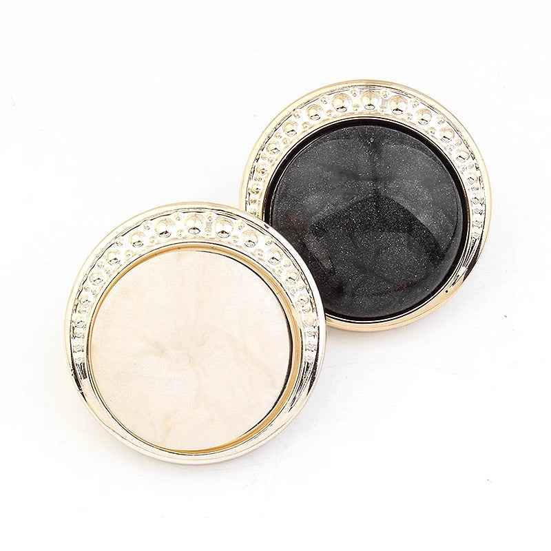 Round resin shank buttons, cream and black pair, silver-tone decorative border around centers