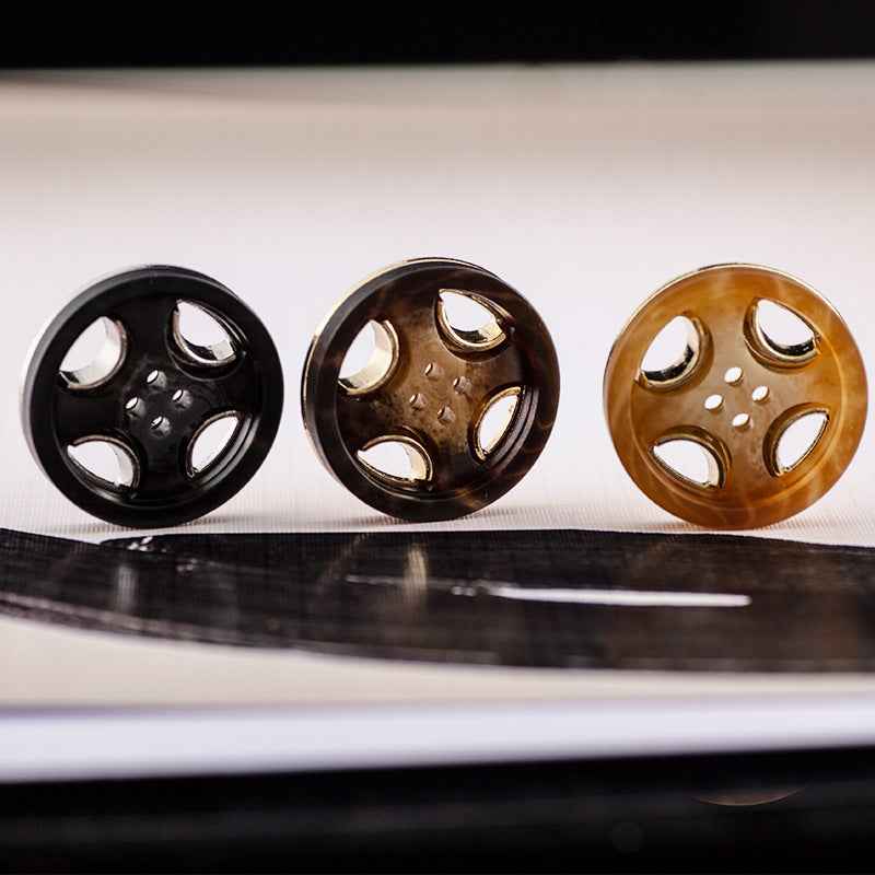 Three round 4-hole resin-metal coat buttons: black, brown, and tan/gold tones