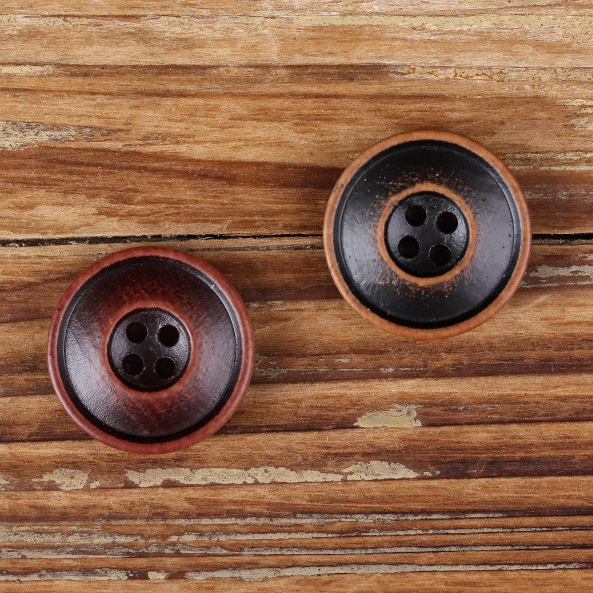 Round 4-hole double-ring buttons on wood grain, red and black