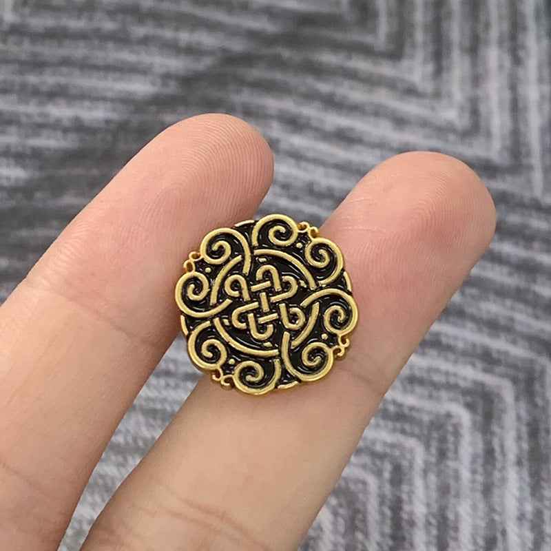 Black gold Chinese knot motif metal button, round with dark filigree center.