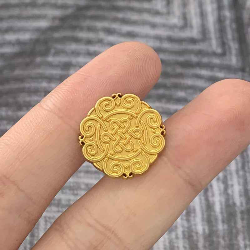 Matte silver Chinese knot motif metal button, round with raised swirl design.