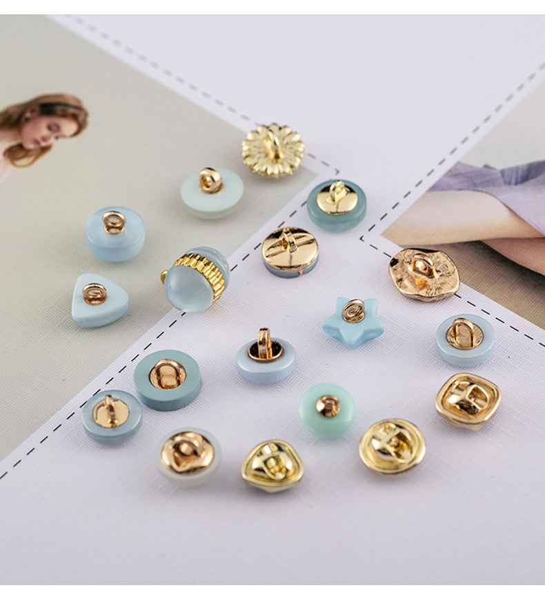 Sortiment Zierknöpfe aus Resin: hellblau, goldfarbene Prägung und florales Motiv
