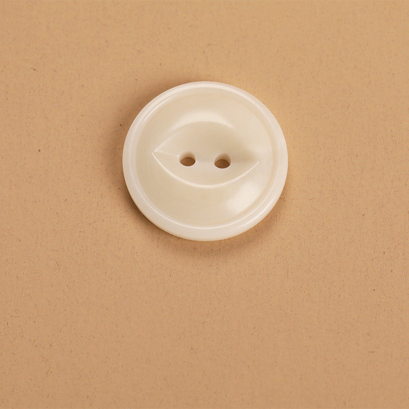 Cream round 2-hole button, close-up side view