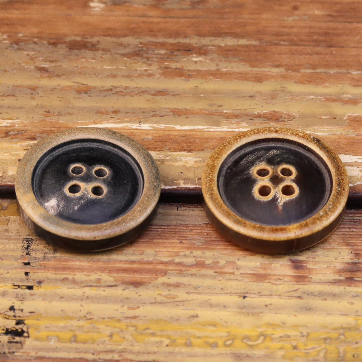 Round 4-hole coat buttons with burnished tan edges, dark face finish