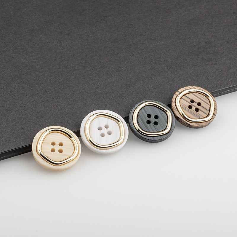 Assorted 4-hole suit buttons in beige, white, black, and brown with gold rims