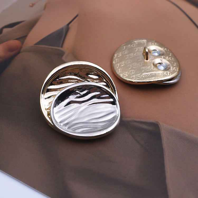 Concave metal shank button with silver front and visible back loops