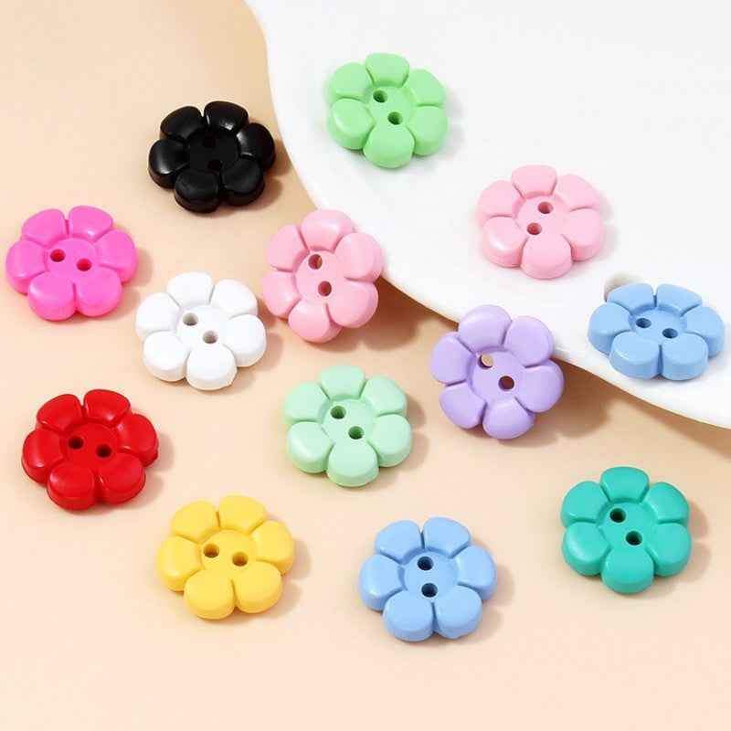 Assorted colorful flower-shaped 2-hole plastic buttons, multiple colors on display