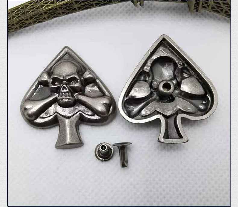 Silver skull-hands spade rivet stud front view with matching hardware pieces